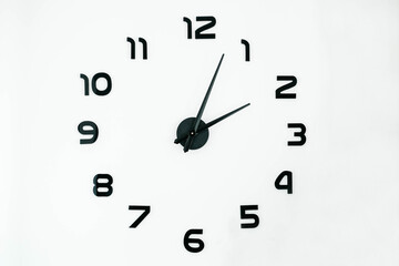 Clock dial with black hands and numbers on a white background. Copy, empty space for text