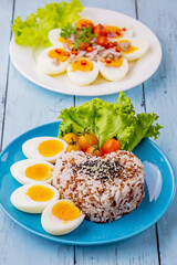 Boiled eggs with rice on blue plate