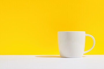 White coffe mug on the table against yellow background