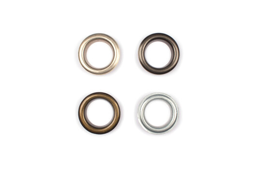 Four brass multicoloured metal eyelets or rivets - curtains rings for fastening fabric to the cornice, isolated on white. With copyspace for text for your presentation