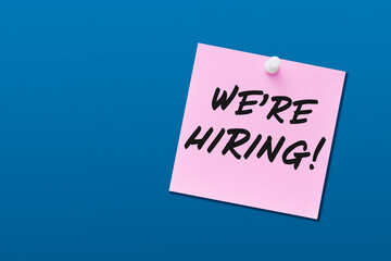 We are hiring note written on note paper attached to a bulletin board