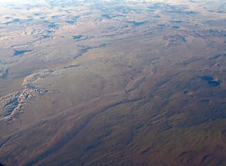 Aerial view of the vast landscape of Arizona region seen from an airplane window.