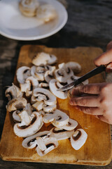 Sliced champignon mushrooms on a wooden board. Country style. High quality photo
