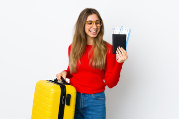 Young woman over isolated white background in vacation with suitcase and passport