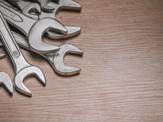 Closeup shot of different sized wrenches on wooden background. .Set of wrenches. Top view. Copy Space
