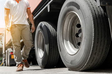 Truck driver walking around semi truck, his checking safety a truck wheels and tires. © Siwakorn1933