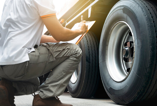 Auto Mechanic is Checking the Truck's Safety Maintenance Checklist. Inspection Safety of Semi Truck Wheels Tires.	