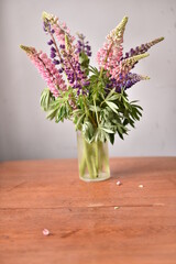 bouquet of colored flowers in a transparent wet vase on the table