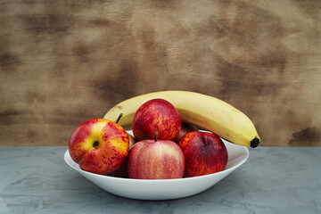 Fruit plate on a concrete base. Light wooden background. Front view.