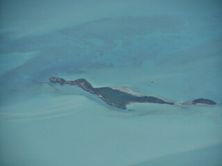 Aerial view of an island in the Exuma Cays Bahamas seen from an airplane window.