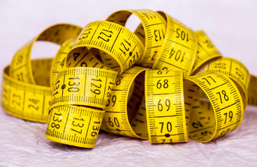 Yellow retro tape measure on pink background, weight loss, diet concept, closeup