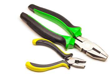 Obraz premium two pliers, large and small, with green-black handles and yellow-black handles, on a white background, isolated