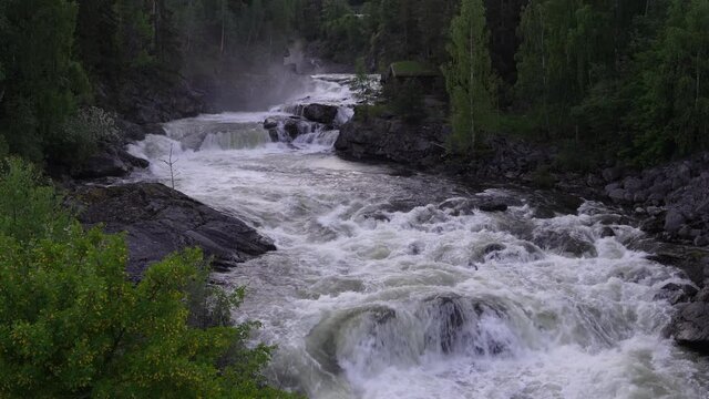 A large river flowing at spring. Hard and fast moving water. Shot in Gol, Hallingdal, Norway.