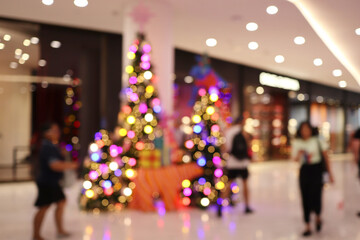 Blurred image of People shopping in department store, Bokeh Christmas Tree,
Defocused blur background.
