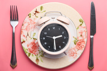 the concept of Healthy Food, alarm clock on plate 