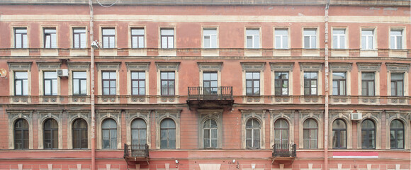 Fototapeta premium Facade of an old residential building with stucco on the wall. Panorama.