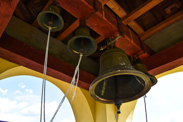 four bronze bells in a bell tower