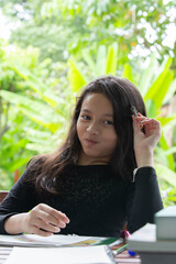 Cute girl doing her homework in the garden at home