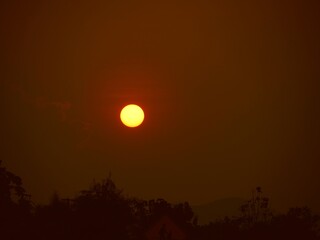 Obraz premium Gorgeous sunset seen above treetops and mountain tops