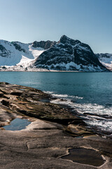 Tungeneset - popular norwegian place on Senja island without tourists. View on the snowy mountains, sea and rocks