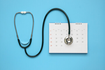 Stethoscope with calendar page date on blue background doctor appointment medical concept