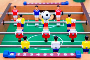 Close up table soccer with players and a ball.