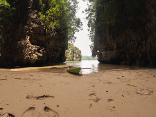 Empty kayak approached in a sandy lagoon among the rocks