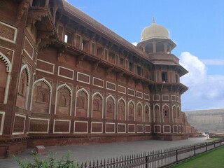 Close up of right side view of the Jahangiri Mahal at the Agra Fort, with white flowers blooming in...