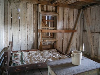 Slaves’ bedroom.Wooden bed with table and a pail inside a slave’s quarters in an old plantation house in Louisiana.