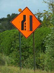 Road sign warning drivers that the lane will end and merge. This is usually posted on the road...