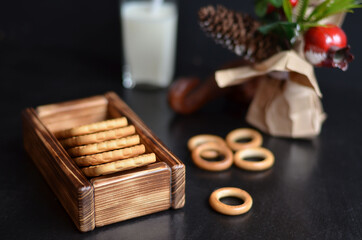 cookies in a wooden box with milk on a black background