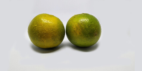 two pieces green lime fruits with a splash of very fresh water on a white background