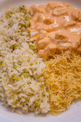 Delicious healthy food with chicken strogonoff with rice and french fries on dish. View from the top