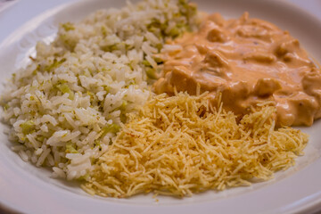 Delicious healthy food with chicken strogonoff with rice and french fries on dish. View from the top