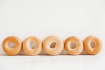 Drying or mini round bagels on a white wooden background. Copy, empty space for text