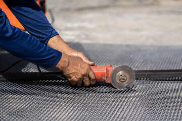 worker'hands  is cutting metal with electric wheel grinder outdoor