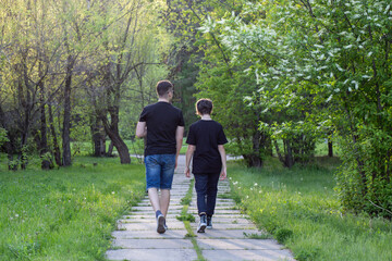 Obraz premium A girl and a guy walk in the park among beautiful spring nature