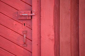 red barn door with handle and key hole and deadbolt lock
