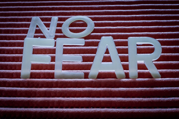 No Fear Motivation Concept. Word written with letters on a striped background, close up.