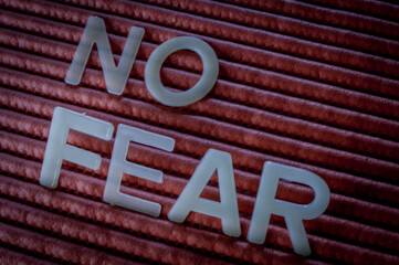 No Fear Motivation Concept. Word written with letters on a striped background, close up.