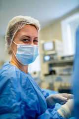 Portrait shot of a nurse looking into camera during operation in the operating room. Professional...