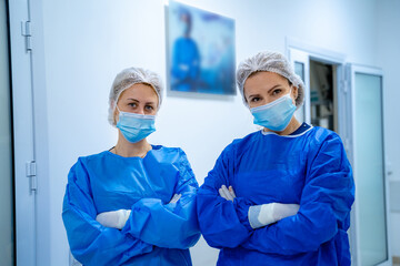 Two female surgeons in operating room with surgery equipment. Medical background, selective focus