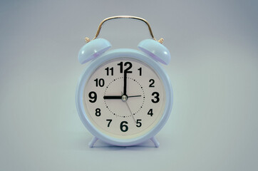 blue alarm clock on a blue background. Image is tinted.