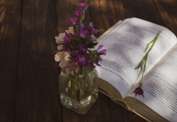 open book and vase on wooden table