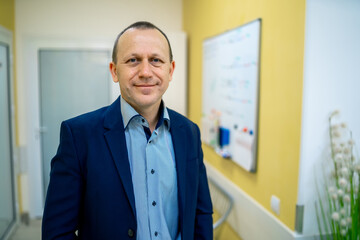 Horizontal photo of professional consultant in suit. Hospital corridor background.