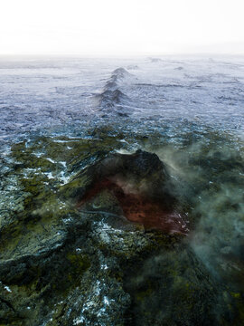 Aerial view of a steaming row of volcanic craters, releasing geothermal heat centuries after eruption, Eldvorp, Reykjanes Peninsula, Iceland