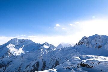 Beautiful jagged rocky mountains of the Alps with large depth of field. Sunny blue-sky skiing day. Beautiful lighting and natural colours. 