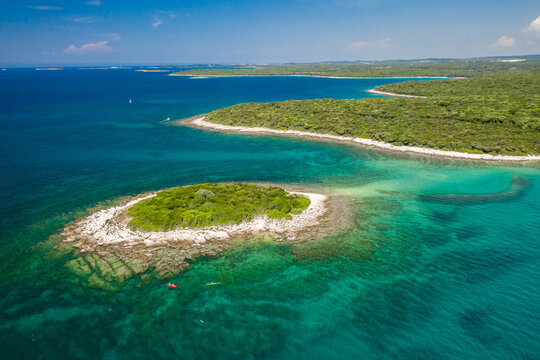 Aerial view of Otocic Kolona island surrounded by turquoise water in Bale, Croatia