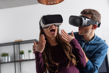 excited girl gesturing near man in virtual reality headset