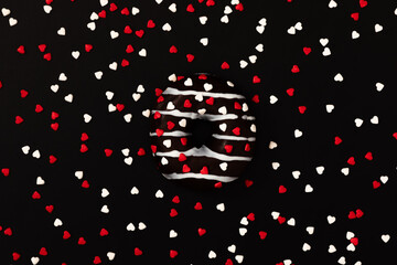 Tasty chocolate donut, heart shaped candy on black background. Flat lay, top view, copy space